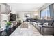 Spacious living room featuring a gray sectional sofa, wood floors, and large window at 11835 Bengals Dr, Fishers, IN 46037