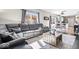 Open-concept living room featuring a spacious sectional couch, table and a peek into the kitchen at 11835 Bengals Dr, Fishers, IN 46037