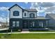 Charming two-story home featuring a welcoming front porch and modern black and white color scheme at 1225 Amberley Way, Westfield, IN 46074