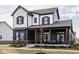 Inviting two-story home showcasing a covered front porch and modern black and white design at 1225 Amberley Way, Westfield, IN 46074