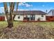 Large backyard with a deck, dining area, and a view of the home's exterior at 13 Watson Dr, Trafalgar, IN 46181