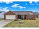 Charming brick ranch with attached garage, covered entryway, and landscaped front yard at 13 Watson Dr, Trafalgar, IN 46181