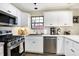 Updated kitchen with white cabinets, stainless steel appliances, and a window overlooking the backyard at 13 Watson Dr, Trafalgar, IN 46181