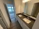 Bathroom featuring double sinks with modern fixtures, a large mirror, and wood floors at 13610 Grand Abbey Way, Fishers, IN 46037