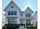 Charming two-story home featuring white siding, black trim windows, brick base, and landscaped front yard at 13610 Grand Abbey Way, Fishers, IN 46037