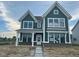 Beautiful craftsman-style home featuring green siding, brick accents, and white trim at 13610 Grand Abbey Way, Fishers, IN 46037