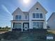 New construction home with a white facade, dark brick foundation, and an inviting covered porch at 13610 Grand Abbey Way, Fishers, IN 46037