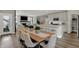 Open floor plan showcasing a dining room with wood table, leading to a modern kitchen and living area with fireplace at 13610 Grand Abbey Way, Fishers, IN 46037