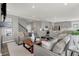 Spacious living room with hardwood floors, grey sofas, and an open kitchen at 13610 Grand Abbey Way, Fishers, IN 46037