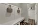 Mudroom with a bench, storage baskets, and coat hooks with a view to an adjacent, well-lit, half-bath at 13610 Grand Abbey Way, Fishers, IN 46037