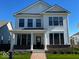 Charming two-story home featuring white siding, black window frames, a brick foundation, and a welcoming front porch at 13622 Grand Abbey Way, Fishers, IN 46037