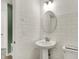 Chic half bathroom with a pedestal sink, modern fixtures, and tiled walls at 13622 Grand Abbey Way, Fishers, IN 46037