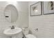 Stylish half bathroom featuring a pedestal sink, subway tile, and decorative artwork at 13622 Grand Abbey Way, Fishers, IN 46037