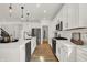 Modern kitchen with white cabinets, stainless steel appliances, and a large island with pendant lighting at 13622 Grand Abbey Way, Fishers, IN 46037