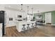 Bright kitchen with white cabinets, stainless steel appliances, island with seating, and modern lighting at 13622 Grand Abbey Way, Fishers, IN 46037