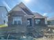 New brick single-Gathering home featuring a covered entry, and a gable roof, awaiting landscaping at 13634 Grand Abbey Way, Fishers, IN 46037