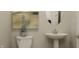 Cozy bathroom with stylish pedestal sink and an oval mirror hanging on the wall at 13634 Grand Abbey Way, Fishers, IN 46037