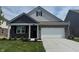 Charming one-story home features brick accents, a two-car garage, and a well-manicured front lawn at 1366 Foxtail Ln, Greenwood, IN 46143