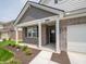 Inviting front porch featuring brick facade, white columns, and well-maintained landscaping around the home's entrance at 1366 Foxtail Ln, Greenwood, IN 46143