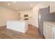 Contemporary kitchen showcases stainless steel appliances, white cabinetry, a center island, and wood-look flooring at 1366 Foxtail Ln, Greenwood, IN 46143
