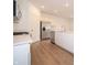 Modern kitchen boasts stainless steel appliances, white cabinetry, wood-look floors, and plenty of countertop space at 1366 Foxtail Ln, Greenwood, IN 46143