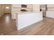 Stylish kitchen island with white cabinetry, countertops, and wood-look floors, perfect for food preparation and dining at 1366 Foxtail Ln, Greenwood, IN 46143