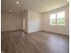 Versatile living room with wood-look flooring, large windows, and a doorway, offering ample space for relaxation at 1366 Foxtail Ln, Greenwood, IN 46143