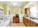 Traditional kitchen with white appliances, bright yellow walls and wood cabinets at 145 W Old South St, Bargersville, IN 46106