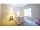 Cozy bedroom with a plush pink throw blanket, bedside lamps, and a bright window for natural lighting at 1502 Heron Ridge Blvd, Greenwood, IN 46143
