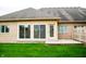 The back exterior of a brick home features sliding glass doors and a small patio at 1502 Heron Ridge Blvd, Greenwood, IN 46143