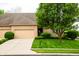 Charming brick home featuring a two-car garage, manicured lawn, and mature landscaping at 1502 Heron Ridge Blvd, Greenwood, IN 46143
