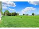 Scenic view of a wide-open green backyard featuring a gentle slope and lush trees at 1627 Clover Crossing Dr, Greenfield, IN 46140