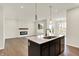 Open floor plan view of kitchen with center island and living room featuring fireplace and large windows at 1627 Clover Crossing Dr, Greenfield, IN 46140