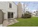 Charming backyard with stone chimney, siding, sliding glass doors, concrete patio, and green grass at 2619 Chaseway Ct, Indianapolis, IN 46268
