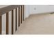 Bright hallway with neutral carpet, white walls, light trim, and wood railing at 2619 Chaseway Ct, Indianapolis, IN 46268