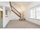 Spacious living room with staircase and carpet, flowing to the entrance and kitchen at 2619 Chaseway Ct, Indianapolis, IN 46268