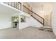 Open-concept living room with staircase leading to loft, adjacent to kitchen at 2619 Chaseway Ct, Indianapolis, IN 46268