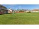Extensive grassy backyard with mature trees, and play equipment, offering plenty of space for outdoor activities at 2838 Violet W Ct, Columbus, IN 47201