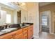 Bathroom features dual sinks with granite countertops, wooden cabinetry, and a large mirror at 2838 Violet W Ct, Columbus, IN 47201