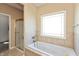 Bright bathroom featuring a bathtub with jacuzzi jets, a glass-enclosed shower, and neutral tile work at 2838 Violet W Ct, Columbus, IN 47201