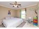 Comfortable bedroom featuring a ceiling fan, cozy bed, and playful wall decorations at 2838 Violet W Ct, Columbus, IN 47201