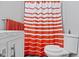 Bright bathroom featuring a vanity, toilet, and shower with orange striped curtain at 2951 E 62Nd St, Indianapolis, IN 46220