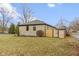 Stone house with a well-manicured lawn, mature trees, and a privacy fence, offering curb appeal and seclusion at 2951 E 62Nd St, Indianapolis, IN 46220