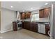 Modern kitchen with stainless steel appliances, dark wood cabinetry, granite countertops, and tile flooring at 2951 E 62Nd St, Indianapolis, IN 46220