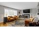 Spacious living room featuring fireplace, flat screen tv, stylish furniture, and large window at 2951 E 62Nd St, Indianapolis, IN 46220