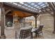 Outdoor kitchen with a built-in grill, counter space, and seating, all under a wooden pergola, ideal for entertaining at 2951 E 62Nd St, Indianapolis, IN 46220