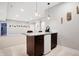 Basement bar with granite countertop, mini fridge, dark cabinets, and modern pendant lights at 3924 Bear Creek Way, Carmel, IN 46074