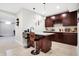 Basement bar with dark wood cabinets, granite countertop, pendant lights, and seating for casual dining at 3924 Bear Creek Way, Carmel, IN 46074