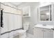 Cozy white bathroom featuring a white shower curtain, toilet, and sink, accented by a decorative mirror at 3924 Bear Creek Way, Carmel, IN 46074