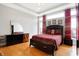 Bright bedroom boasts tray ceiling, hardwood floors, large windows with red drapes, and a dark wood dresser at 3924 Bear Creek Way, Carmel, IN 46074